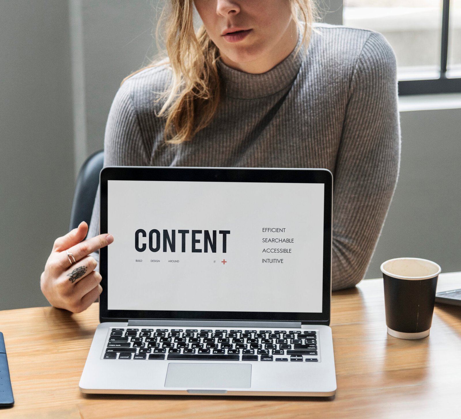 Blond woman pointing at a laptop screen